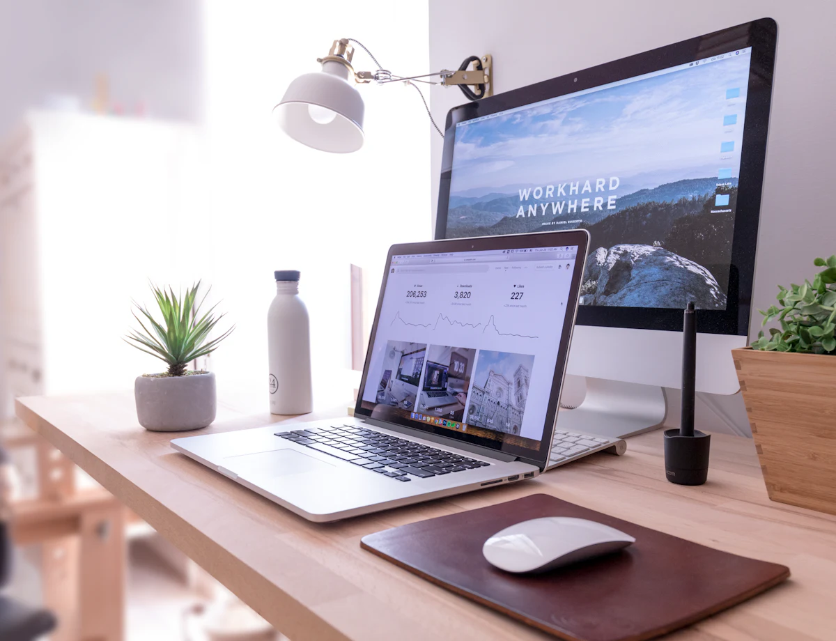 A designer's desk, a website shown on the screen and on the laptop