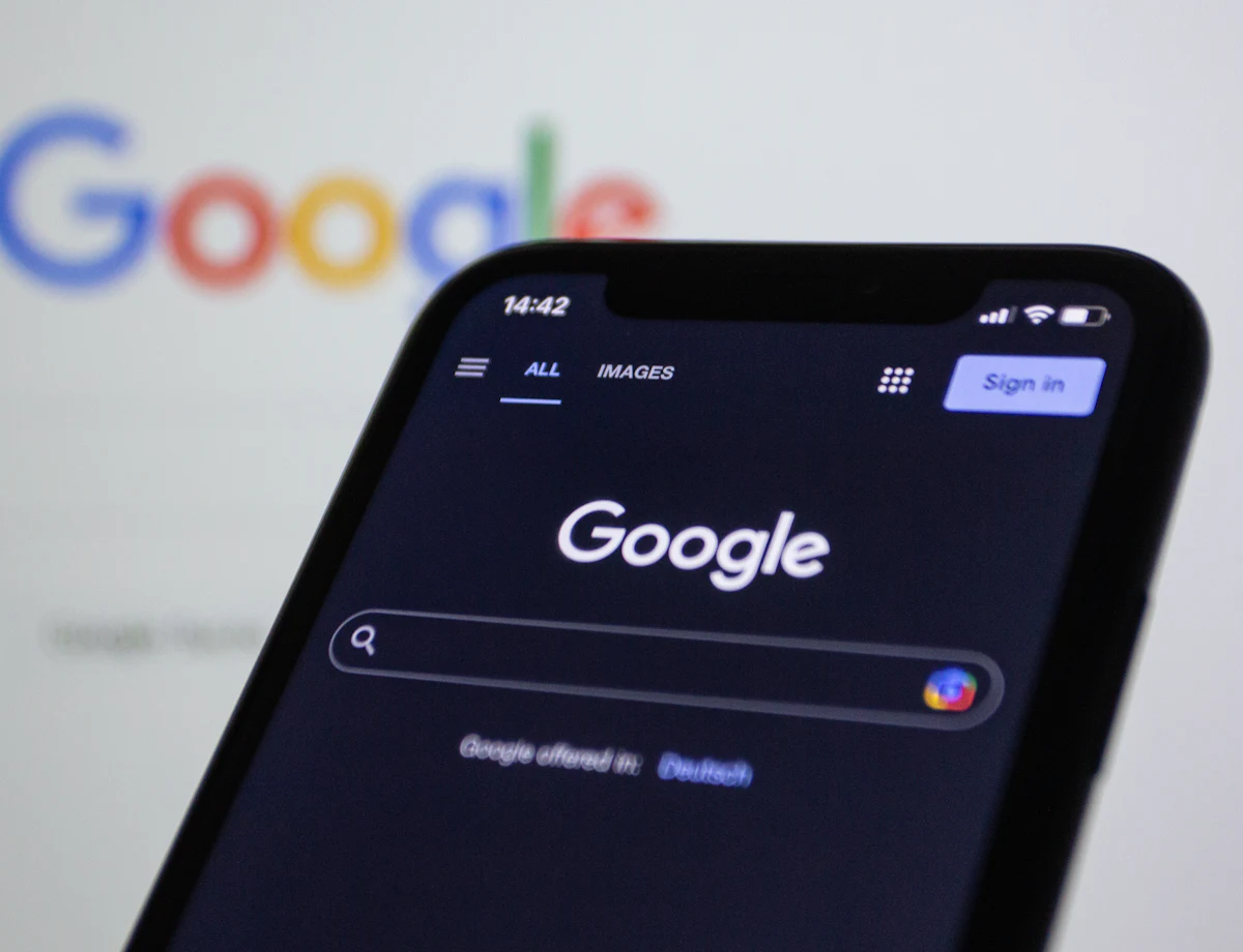 A phone showing a Google search in front of the Google logo