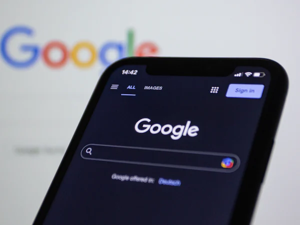 Un téléphone affiche la recherche Google devant le logo Google